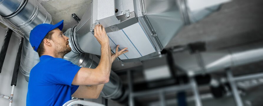 Technician installing HVAC ductwork