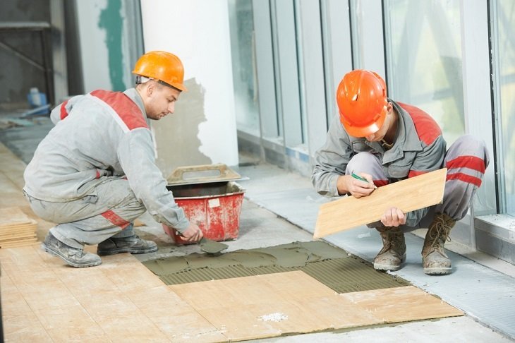 Technicians laying floor tiles